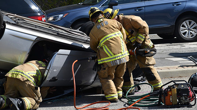 firefighters assisting with car flipped over