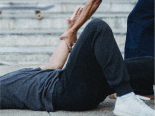 man who has fallen on the ground and is being helped