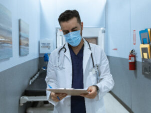 man walking down hospital hallway