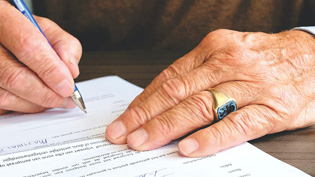 man completing paperwork with a pen