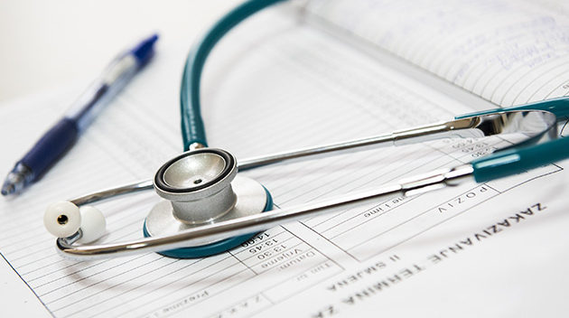 stethoscope and pen sitting on paperwork